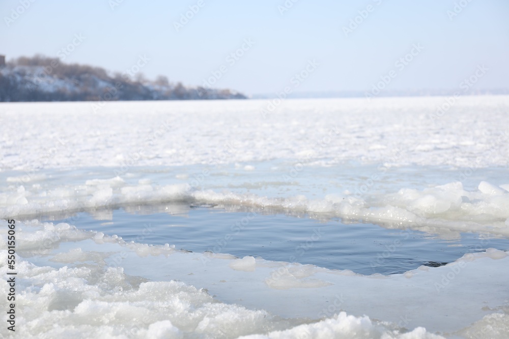 Ice hole in river on winter day. Baptism ritual Ice hole in river on winter day. Baptism ritual