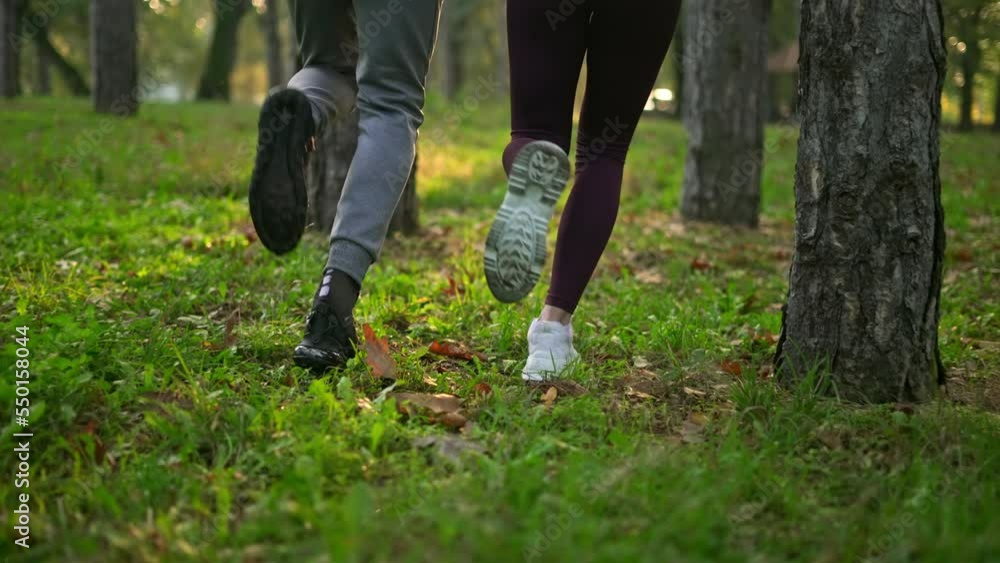 Close up of male and female legs running in the park. Close up of male and female legs running in the park.