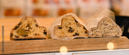 Close-up of Stollen, traditional German sweet fruit bread for Christmas with raisins and marzipan coated with powdered sugar also called Weihnachtsstollen or Christstollen, landscape header image