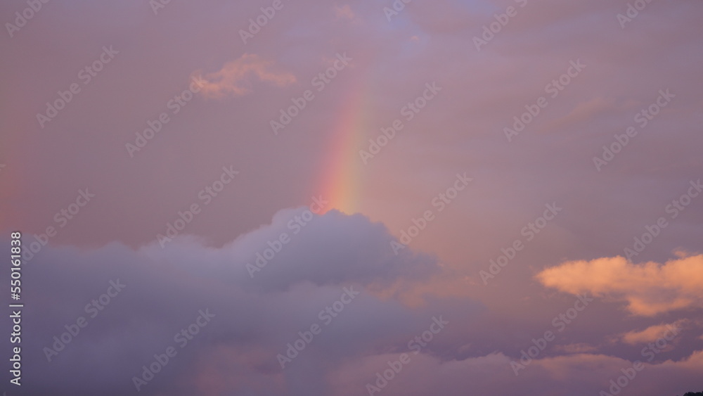 The colorful rainbow rising up in the sky after the summer rainning