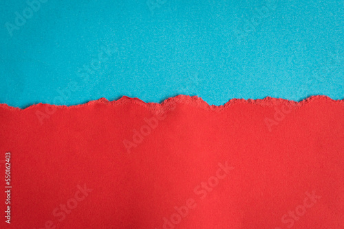 Torn half sheet red paper horizontal on blue paper at the bottom. As template for message or advertisement.