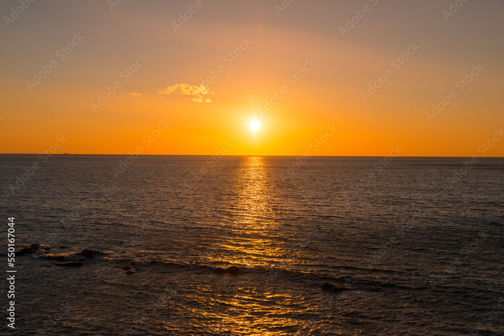 海岸と海に朝日の太陽