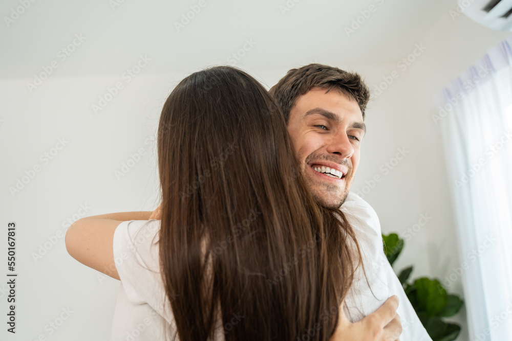 Caucasian young man and woman hugging each other in living room at home. Caucasian young man and woman hugging each other in living room at home.