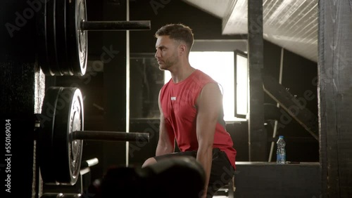 Young athletic man doing lunge squat ecercise with dumbbells in the gym. Healthy lifestyle concept. Slow motion.  photo