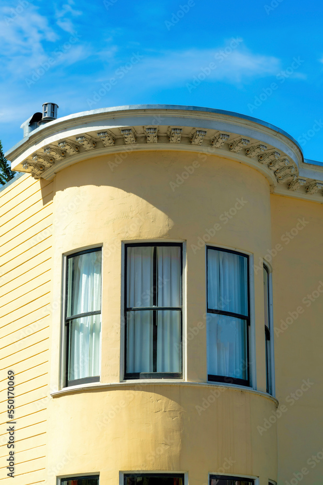 Round spire or turrent on side of building with panoramic windows on beige structure in the city midday sun Round spire or turrent on side of building with panoramic windows on beige structure in the city midday sun