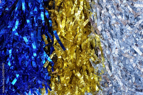 Close up colorful blue, silver and gold pompoms on white background