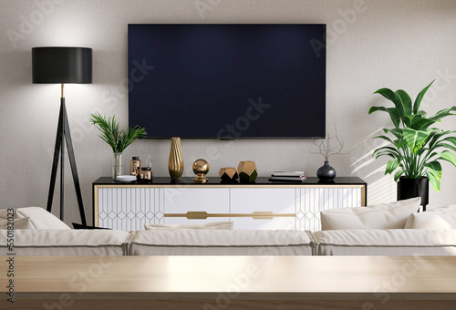 Wooden table top, countertop in modern, luxury design living room with sofa, black and white cabinet, floor lamp with smart tv on beige wall for lifestyle, household product display background