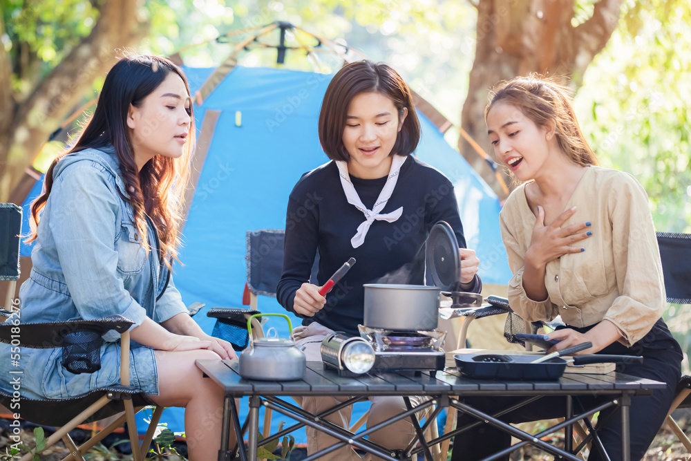 Happy group girls outdoor camping and cooking in nature forest summer holidays.