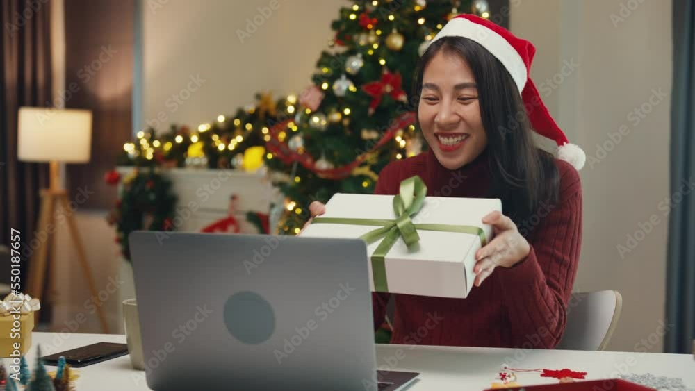 Attractive Asia female blogger new normal shopping online christmas gift unbox review celebrate christmas video conference call with follower on computer laptop in social media platform at house. Attractive Asia female blogger new normal shopping online christmas gift unbox review celebrate christmas video conference call with follower on computer laptop in social media platform at house.