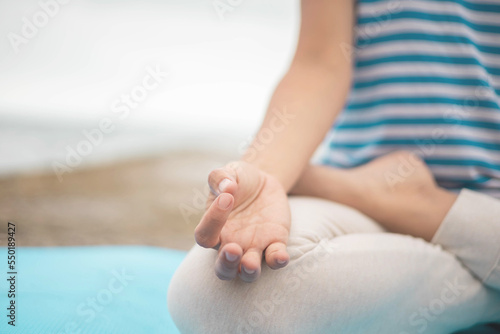 Closeup female yoga hands mudra fingers connected lotus position meditation on beach peace of mind