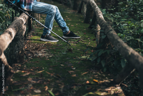 hiker with backpack sitting on old wood fence in the forest while a rest. hiking and adventure concept.
