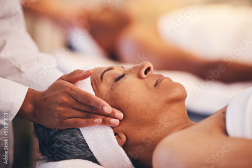 Hands, head and massage with a woman in a spa for wellness or luxury treatment to relax and rest. Face, zen and stress relied with a senior female relaxing in a health salon for physical therapy