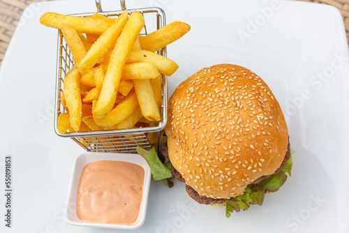 Hamburger and fries with pink sauce dip. Classic burger combo meal on white plate from top photo