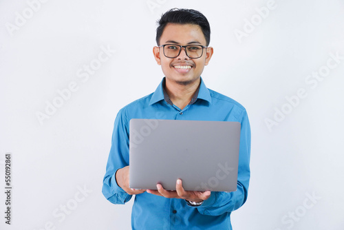 smiling or happy asian businessman with glasses holding laptop wearing blue shirt isolated on white background