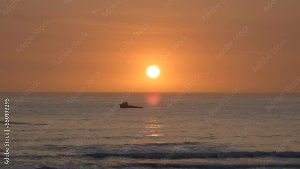 A single bird flies by in front of an orange sunset and a beautiful orange sky. A lone ship can be seen in the ocean horizon. Shot in 4k, 30 fps. Recorded in Punta Hermosa beach in Lima, Peru. A single bird flies by in front of an orange sunset and a beautiful orange sky. A lone ship can be seen in the ocean horizon. Shot in 4k, 30 fps. Recorded in Punta Hermosa beach in Lima, Peru.