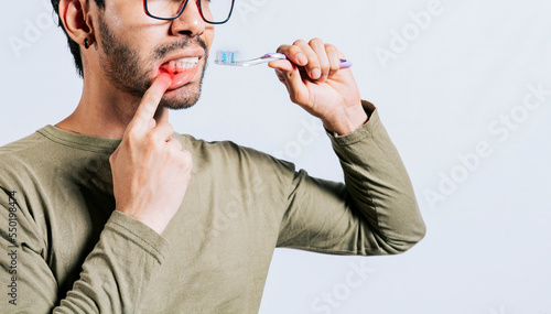 People holding toothbrush with gum pain. Man holding toothbrush with gum pain, People holding toothbrush with gum problem isolated. Young man with gingivitis holding toothbrush photo