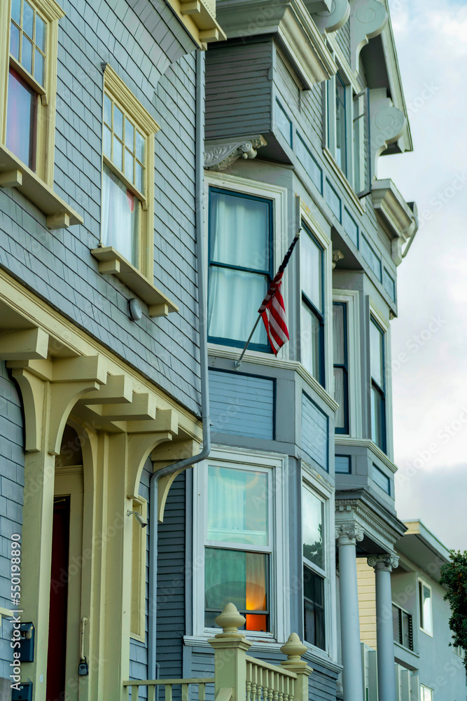 Row of house facades in the historic districts of San Francisco California in late afternoon shade with foggy background sky Row of house facades in the historic districts of San Francisco California in late afternoon shade with foggy background sky