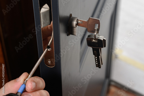 Installation of lock and door handle to interior doors, locksmith works with doors. photo