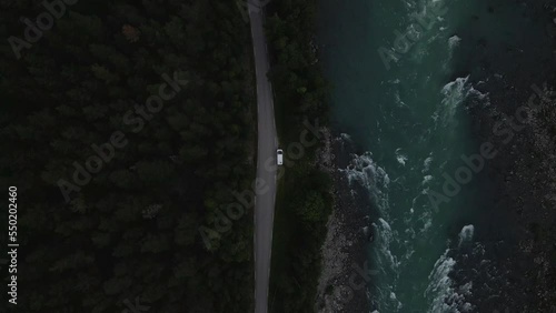 Aerial drone top down shot over road beside Gudbrandsdalslågen river with rapids flowing along valley of Gudbrandsdalen in Innlandet, Norway at daytime. photo