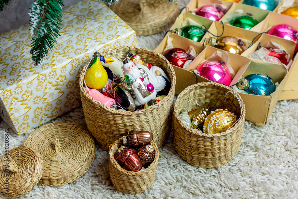 Vintage Christmas decorations in round baskets and glass balls in a box under the Christmas tree.