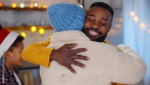 African-American family welcome and hug friend coming to celebrate christmas together