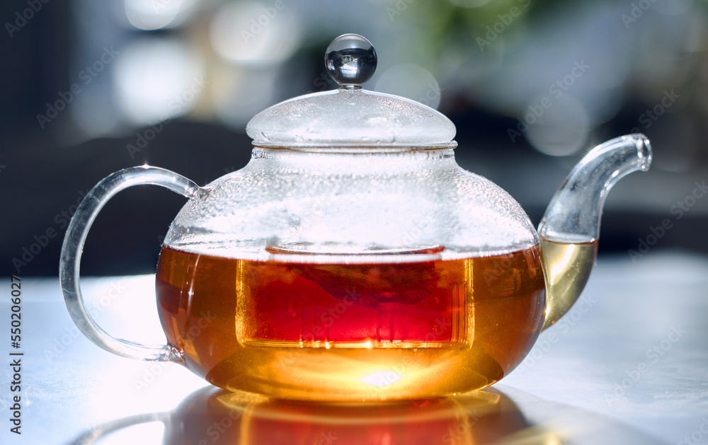 Tea, drink and fresh with a bag in a glass pot for drinking, refreshment or brewing on a table in the kitchen. Herbal, health and natural with an organic beverage to boost your immune system Tea, drink and fresh with a bag in a glass pot for drinking, refreshment or brewing on a table in the kitchen. Herbal, health and natural with an organic beverage to boost your immune system