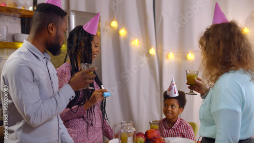 Foto Happy parents and godmother singing happy birthday song to preteen boy celebrati