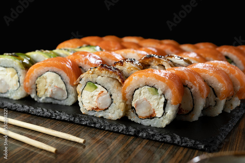 Sushi Set with salmon, prawn and sushi rolls philadelphia served on served on stone slate. Japanese Food