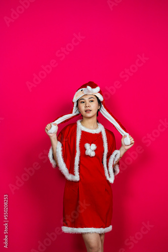 A Woman Posing on an Isolated Red Background With Christmas Attire