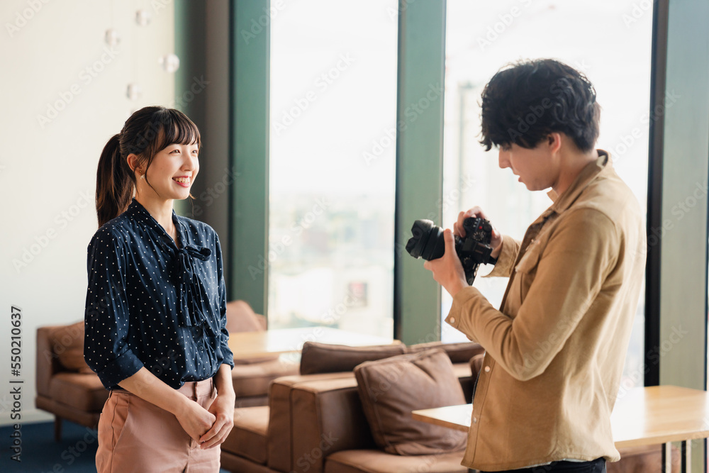 Fototapeta premium 女性のポートレート写真を撮影する男性フォトグラファー