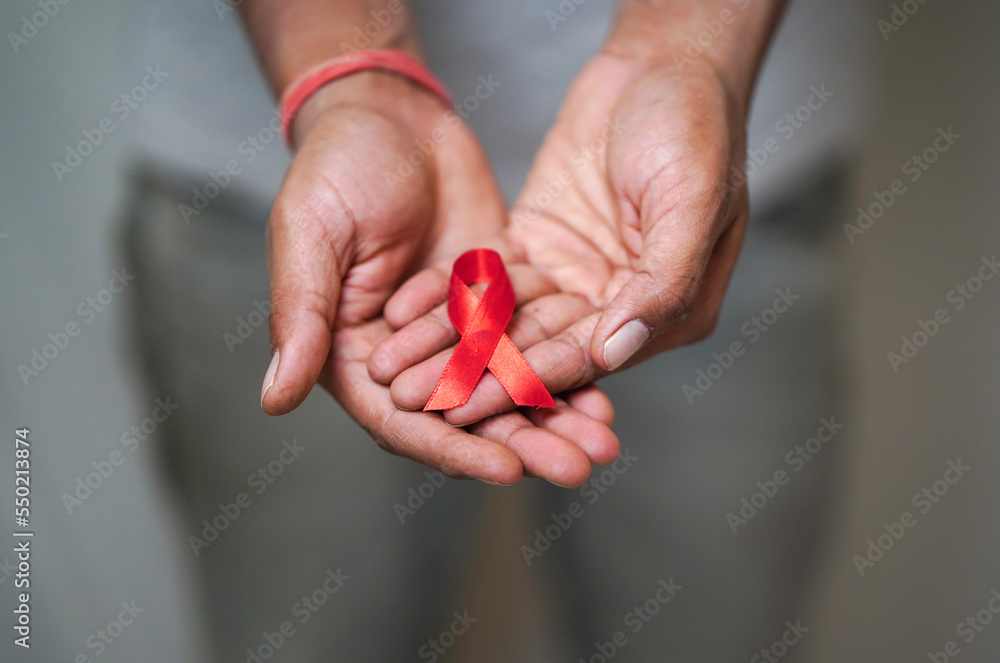 Worlds HIV Aids Day, Men Holding A red ribbon In his hand, HIV Aids Awareness, Close up shot of Men Holding Red ribbon in white background HIV AIDS concept, Health Concept Worlds HIV Aids Day, Men Holding A red ribbon In his hand, HIV Aids Awareness, Close up shot of Men Holding Red ribbon in white background HIV AIDS concept, Health Concept
