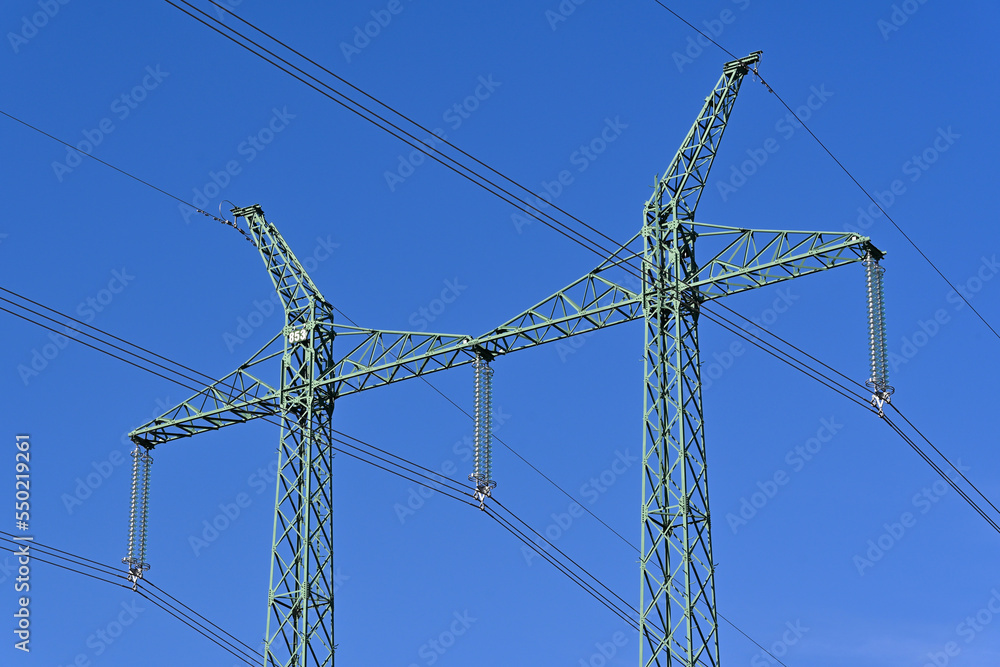 The top of the tower for electrical transmission line. Close-up with glass disk insulators and electric cables. The top of the tower for electrical transmission line. Close-up with glass disk insulators and electric cables.