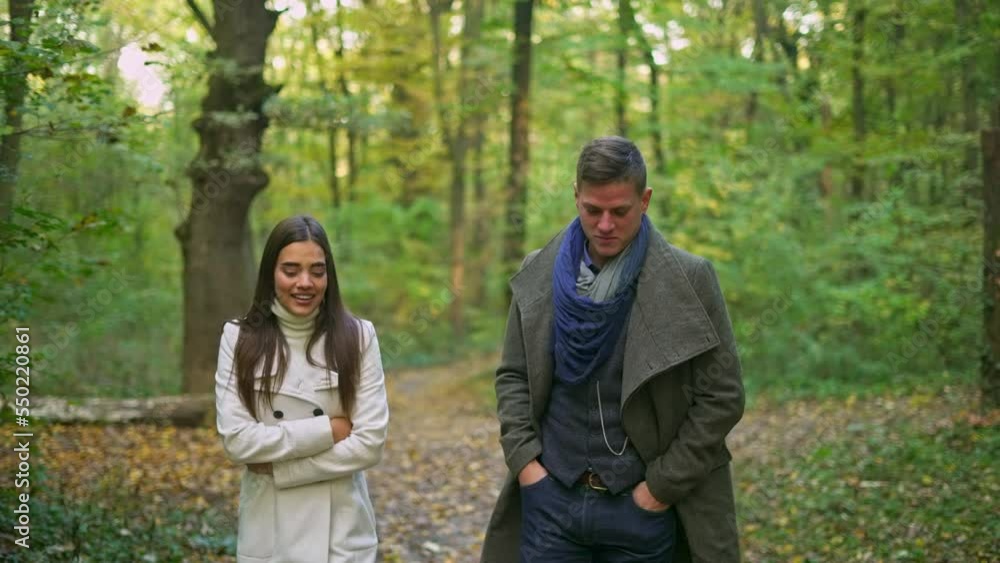 Happy young couple spending time together during pleasant walk in autumn forest. Happy young couple spending time together during pleasant walk in autumn forest.