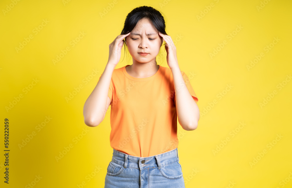 Asian girl posing on yellow background Asian girl posing on yellow background
