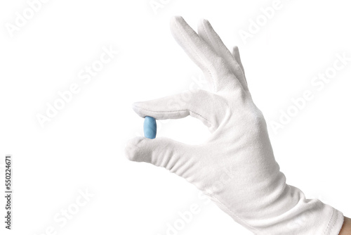 Blue pill in hand. A gloved hand holds a pill. Medicines