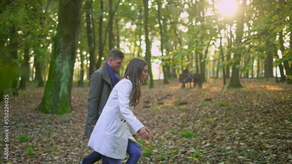 Beautiful young woman and handsome man enjoying time together during pleasant walk in autumn park. Beautiful young woman and handsome man enjoying time together during pleasant walk in autumn park.