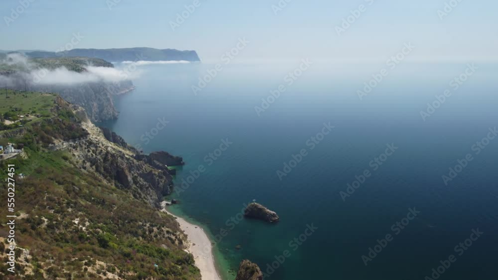 Aerial view from above on calm azure sea and volcanic rocky shores. Small waves on water surface in motion blur. Nature summer ocean sea beach background. Nobody. Holiday, vacation and travel concept Aerial view from above on calm azure sea and volcanic rocky shores. Small waves on water surface in motion blur. Nature summer ocean sea beach background. Nobody. Holiday, vacation and travel concept