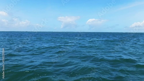 view of a choppy ocean under a blue sky. Close up shot