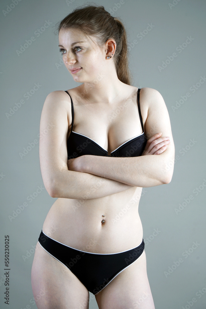 Sporty young woman posing in black bikini in studio