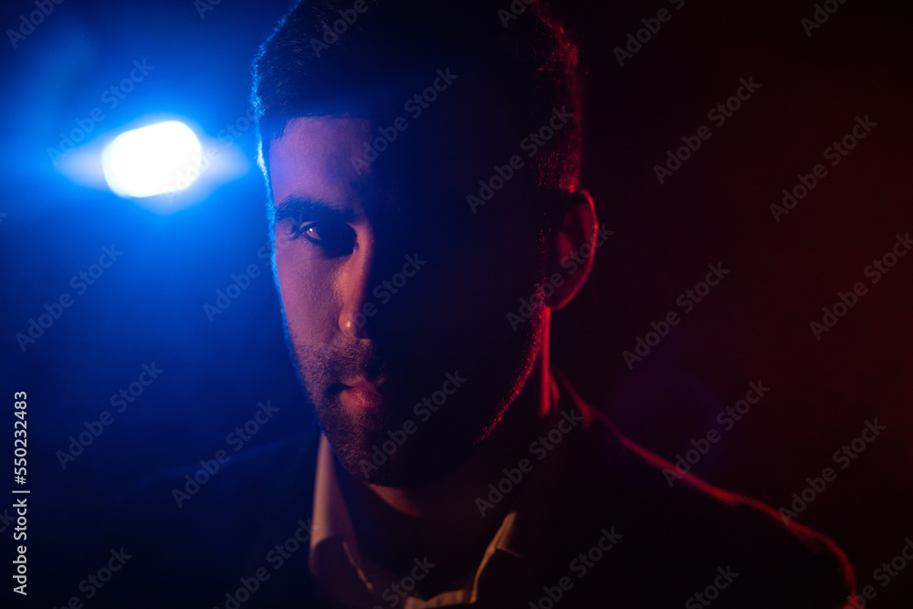 Photo of standing man and pink light on the background. Photo of standing man and pink light on the background.