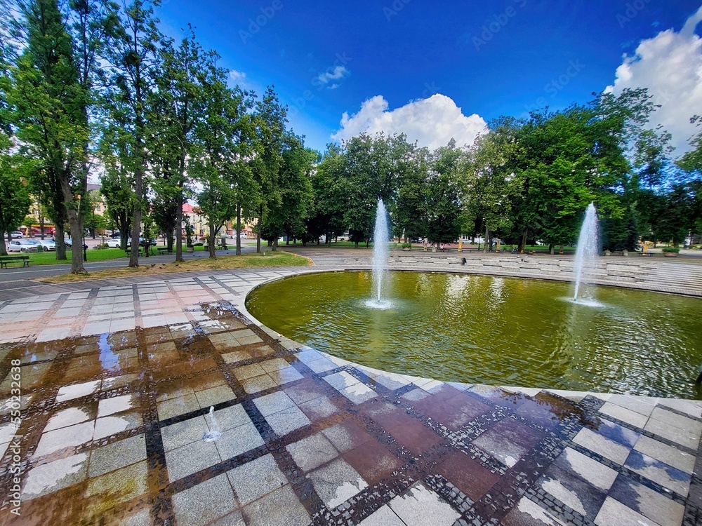 Fountain in the park. Large dock with cover and big house at the