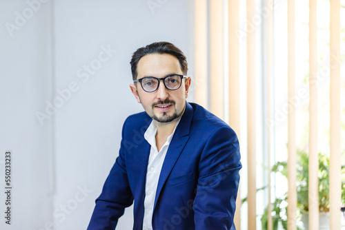 Photo of a businessman in blue suit in the office.