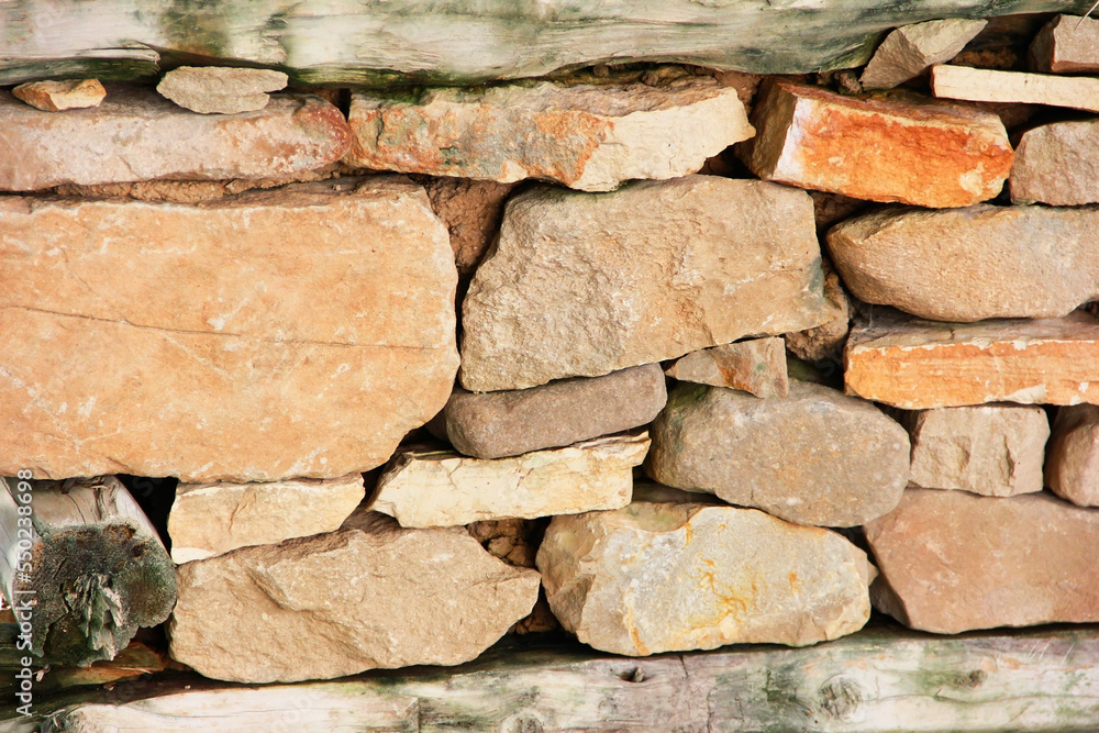 the texture of a stone wall made of brown stones and old moldy wood the texture of a stone wall made of brown stones and old moldy wood
