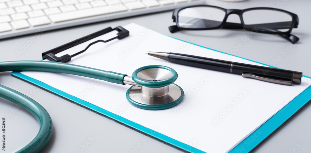 Stethoscope with clipboard and pen on doctor desk Stethoscope with clipboard and pen on doctor desk