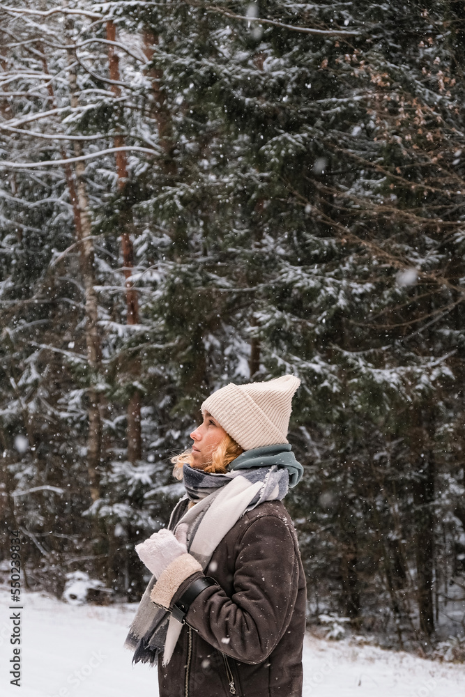 Fototapeta premium Winter.woman walks through winter snowy forest. Mental and physical health. Unity with nature.travel outdoors, hiking, spending time outdoors,winter travel,slow life,christmas forest.