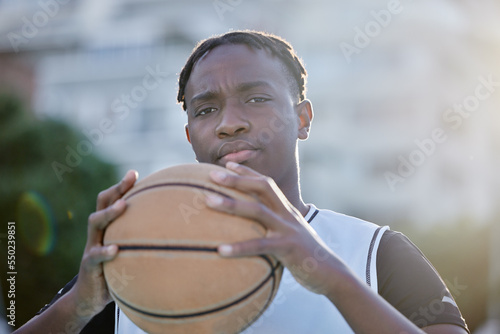 Basketball, cool and a tough player training for a game on a basketball court. Portrait of a serious professional athlete focused on his sport career, looking ready, powerful and assertive