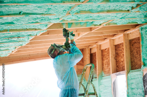 Photography Male builder insulating wooden frame house