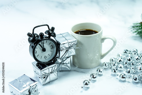 Christmas decorations on the table with a cup of coffee and an alarm clock. Christmas background. Merry Christmas greeting card, frame, banner. Space for text. Selective focus. 