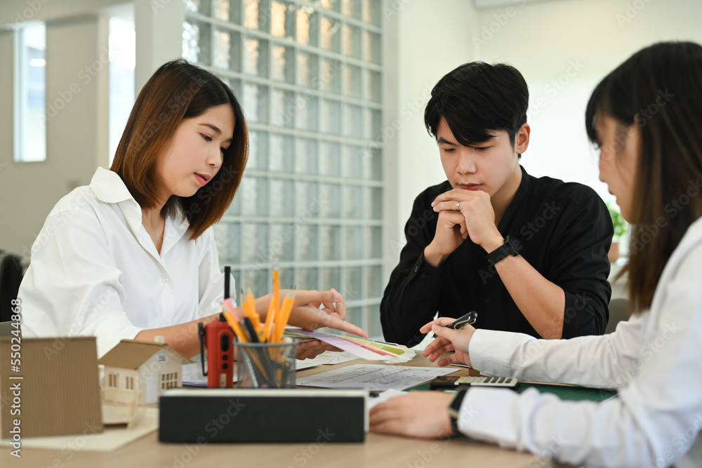 Engineer or architect team brainstorming, planning development details at construction office Engineer or architect team brainstorming, planning development details at construction office