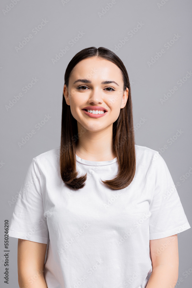 Portrait close up shot of beautiful adorable pretty woman looking at camera smiling with white teeth standing on grey background isolated. Portrait close up shot of beautiful adorable pretty woman looking at camera smiling with white teeth standing on grey background isolated.